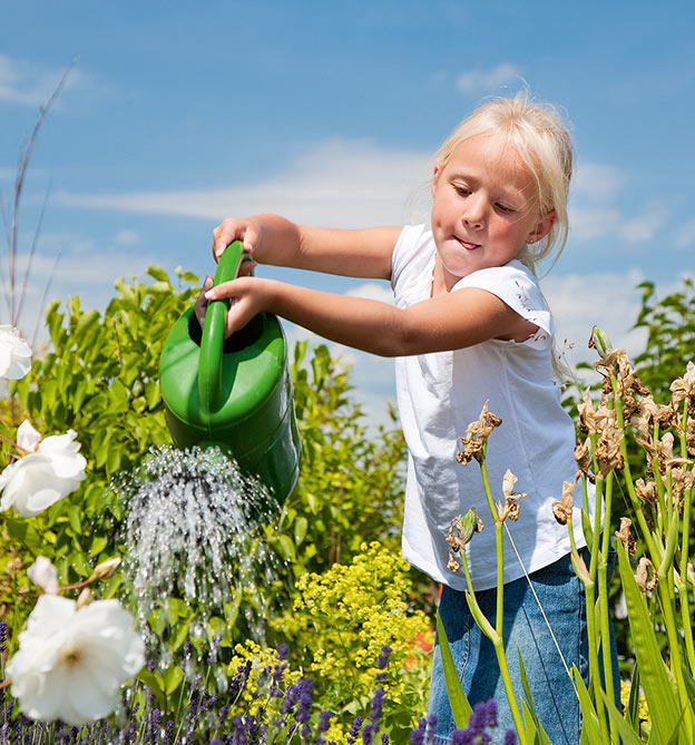 Kleines Mädchen giesst Blumen