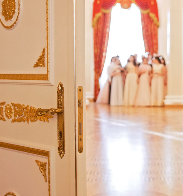 Offene Tür mit Frauen in weißen Kleidern im Hintergrund